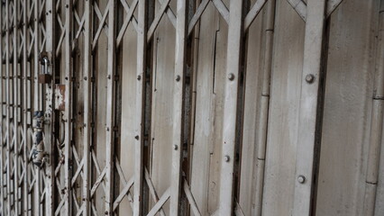 Old metal folding gate with weathered texture and rust details, representing urban background, security concept, and industrial surface.
