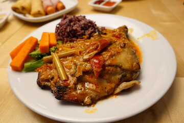 Traditional Thai curry fish served with rice and vegetables on a plate, showcasing authentic Thai cuisine and local food culture.