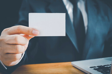 businessman hand showing blank white business card closeup.