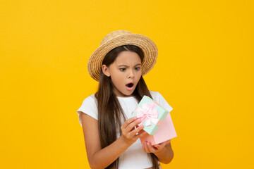 shocked teen kid hold gift box on yellow background