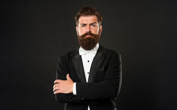 elegant butler in tuxedo on black background, fashionist