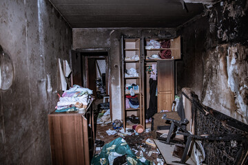 Destroyed housing after the fire, burnt things, soot and coals  everywhere