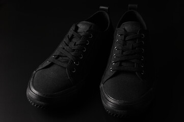 Black sneakers on black background