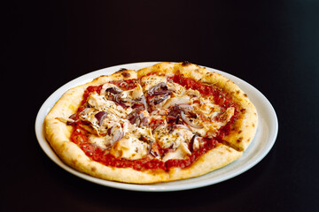 Close-up view to fresh pizza with tomato sauce, chicken and red onion