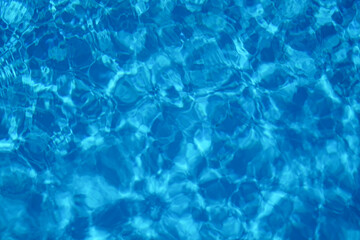 Fototapeta na wymiar Wavy water surface of swimming pool, top view
