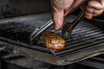 An organic  marinated duck fillet being grilled