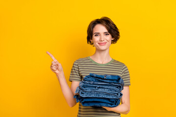 Photo of dreamy sweet girl dressed green t-shirt selling clothes pointing empty space isolated yellow color background