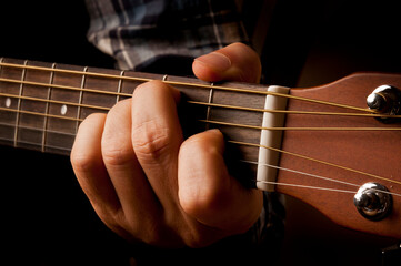 close up of a muscian hands playing a classic acoustic guitar