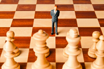 businessman miniature figurine on a chessboard, strategy and marketing decisions