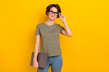 Photo of charming cute girl dressed green t-shirt arm eyewear holding modern gadget empty space isolated yellow color background