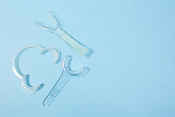set of several Retractor Dental lip retractor Access to the oral cavity. Wide mouth opening for a dental procedure on a clean blue background