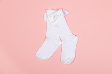 high white children's socks for girls with big bows for party wear on a pink background