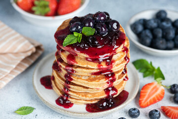 Stack of american pancakes with blueberry sauce. Sweet breakfast or lunch food.