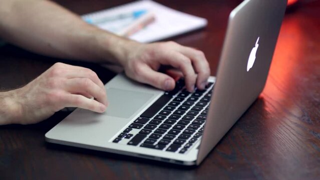 MAN TYPING ON LAPTOP