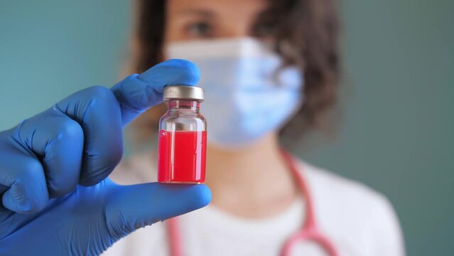 Woman Doctor holds an ampule with medicine in her hand. vaccine for disease in doctor hand. the doctor prescribed an injection treatment. doctor is ready to give an injection to patient