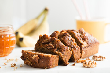 Homemade gluten free banana bread with walnuts cut into slices, closeup view - 519162565