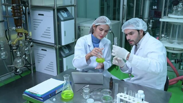 Scientists and assistants are in the oil and cannabis seed extractor room. The extracted cannabis oil is being tested and examined.