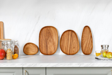 Kitchen view. Wooden oak dishes, boards, trays standing near the wall. Empty wooden plates on kitchen countertop.
