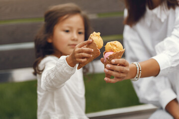 Mother with daughter eats ice cream in the city