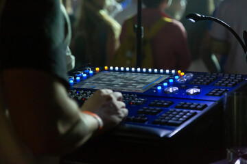 Soundman working on the mixing console in concert hall.