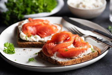 Rye bread sandwich with salmon and cream cheese, closeup view