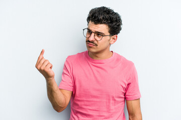 Young caucasian man isolated on blue background pointing with finger at you as if inviting come closer.