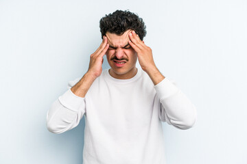 Young caucasian man isolated on blue background having a head ache, touching front of the face.