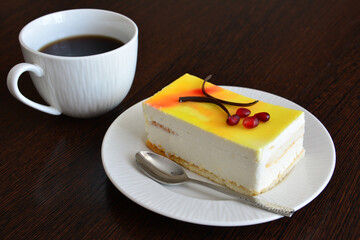 lemon cake decorated with chocolate on white saucer with cup of coffee, close-up