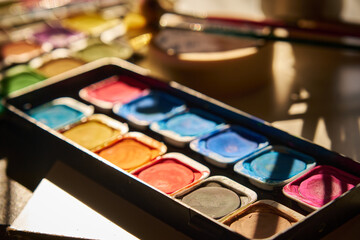 watercolor paints are laid out on the table