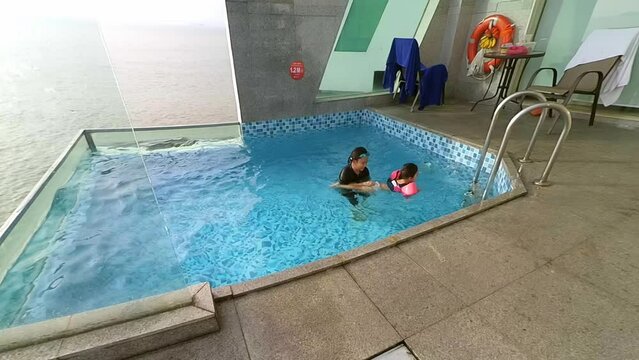 Happy children swimming in a pool villa. A fun weekend spent together._