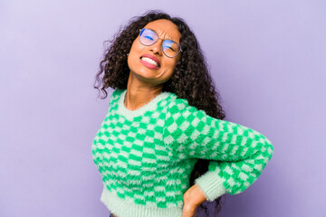 Young hispanic woman isolated on purple background suffering a back pain.