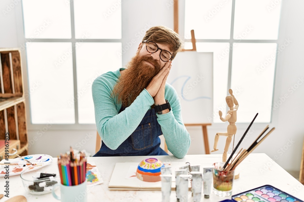 Sticker redhead man with long beard painting clay bowl at art studio sleeping tired dreaming and posing with