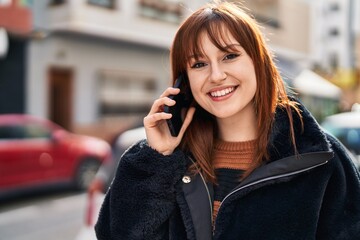 Young woman smiling confident talking on the smartphone at street