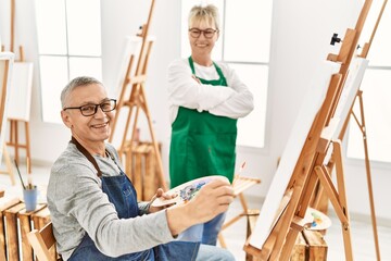 Two senior paint student smiling happy painting at art studio.