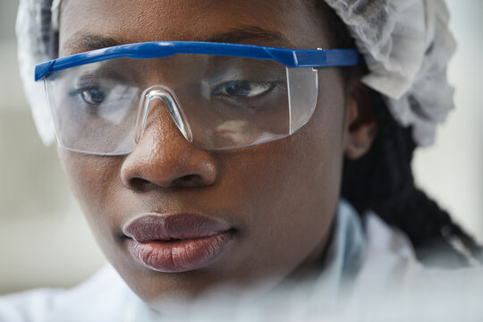 Extreme Close Up Of Black Female Scientist Wearing Protective Glasses In Lab