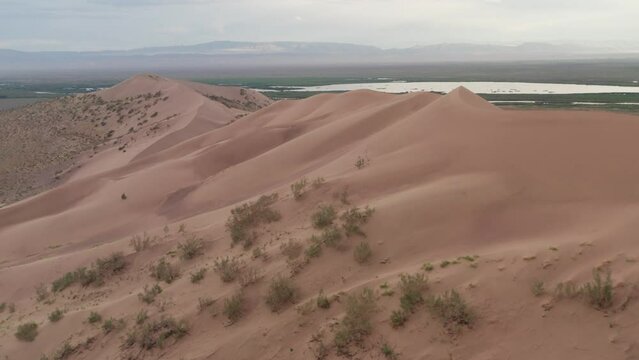 Beautiful sand dune in the wild. Aerial footage of The Singing Dune, or Aigaikum in Altyn-Emel National Park.