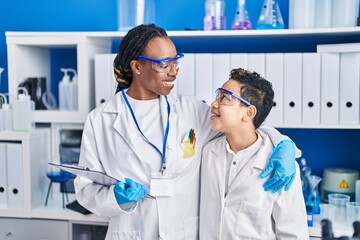 African american mother and son scientists smiling confident standing together laboratory