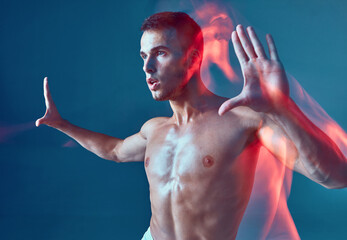 Contemporary dance. Handsome young male with naked muscular torso raises arms, dancing zumba. Long...
