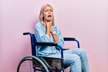 Beautiful blonde woman sitting on wheelchair shouting suffocate because painful strangle. health...