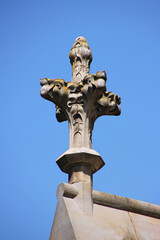 Fototapeta na wymiar Restored gothic cross flower sculpture on the roof ridge of St Michel cathedral in the city of Carcassonne, Occitanie region in France