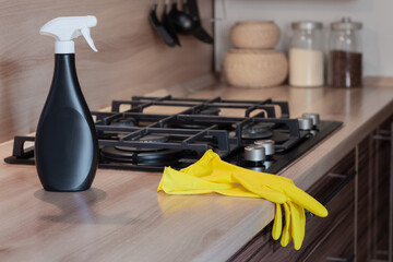 professional cleaning, yellow rubber gloves and a bottle of cleaning agent in a clean kitchen