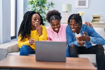 African american friends having video call sitting on sofa at home