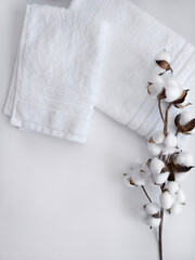 White towels with cotton flower branch on the white background