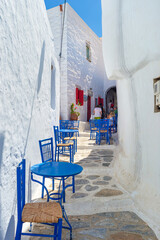 Traditional greek street with tables in Amorgos island, Greece islands - obrazy, fototapety, plakaty