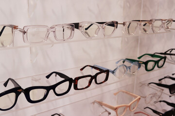 Optics salon. Shelf with fashionable modern eyeglass frames. Massive medical glasses. The concept of an optics store.