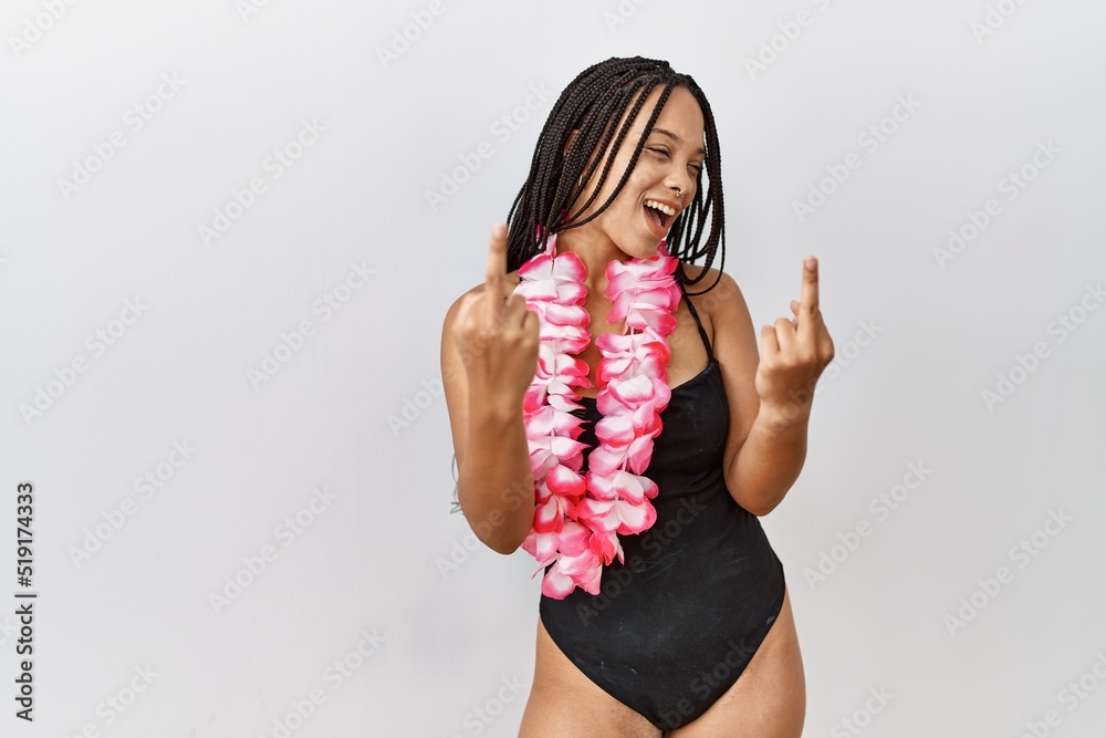 Canvas Prints Young african american woman wearing swimsuit and hawaiian lei showing middle finger doing fuck you bad expression, provocation and rude attitude. screaming excited