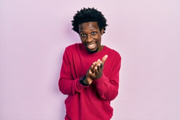 Young african american man wearing casual clothes clapping and applauding happy and joyful, smiling...