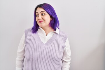 Plus size woman wit purple hair standing over white background smiling looking to the side and staring away thinking.