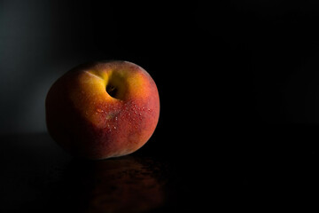 Durazno melocotón aislado sobre fondo oscuro. Espacio texto.