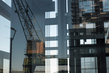 Blick durch ein gläsernes Treppenhaus auf einen historischen Kran am Kölner Rheinauhafen